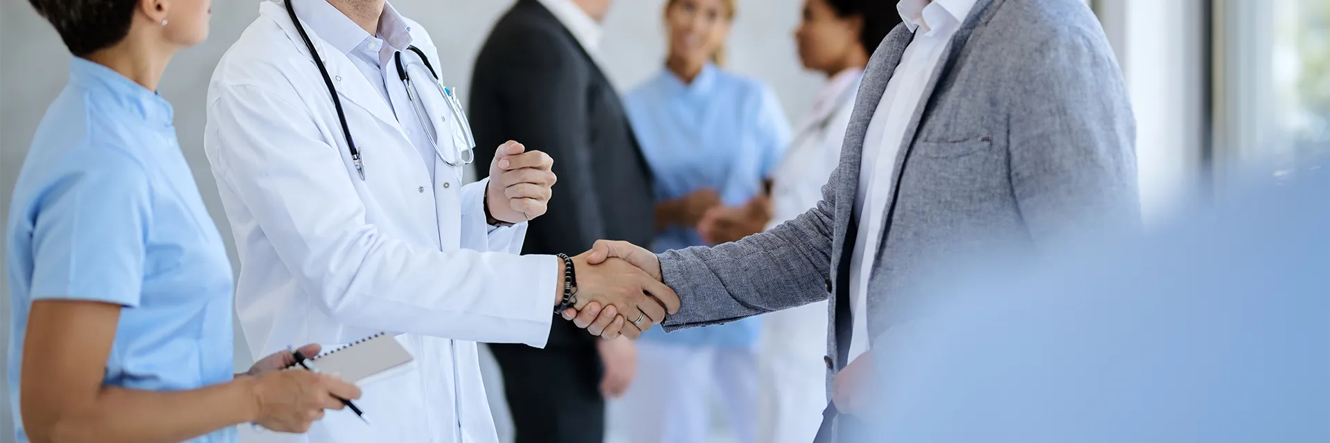 Professional handshake between doctor and business partner